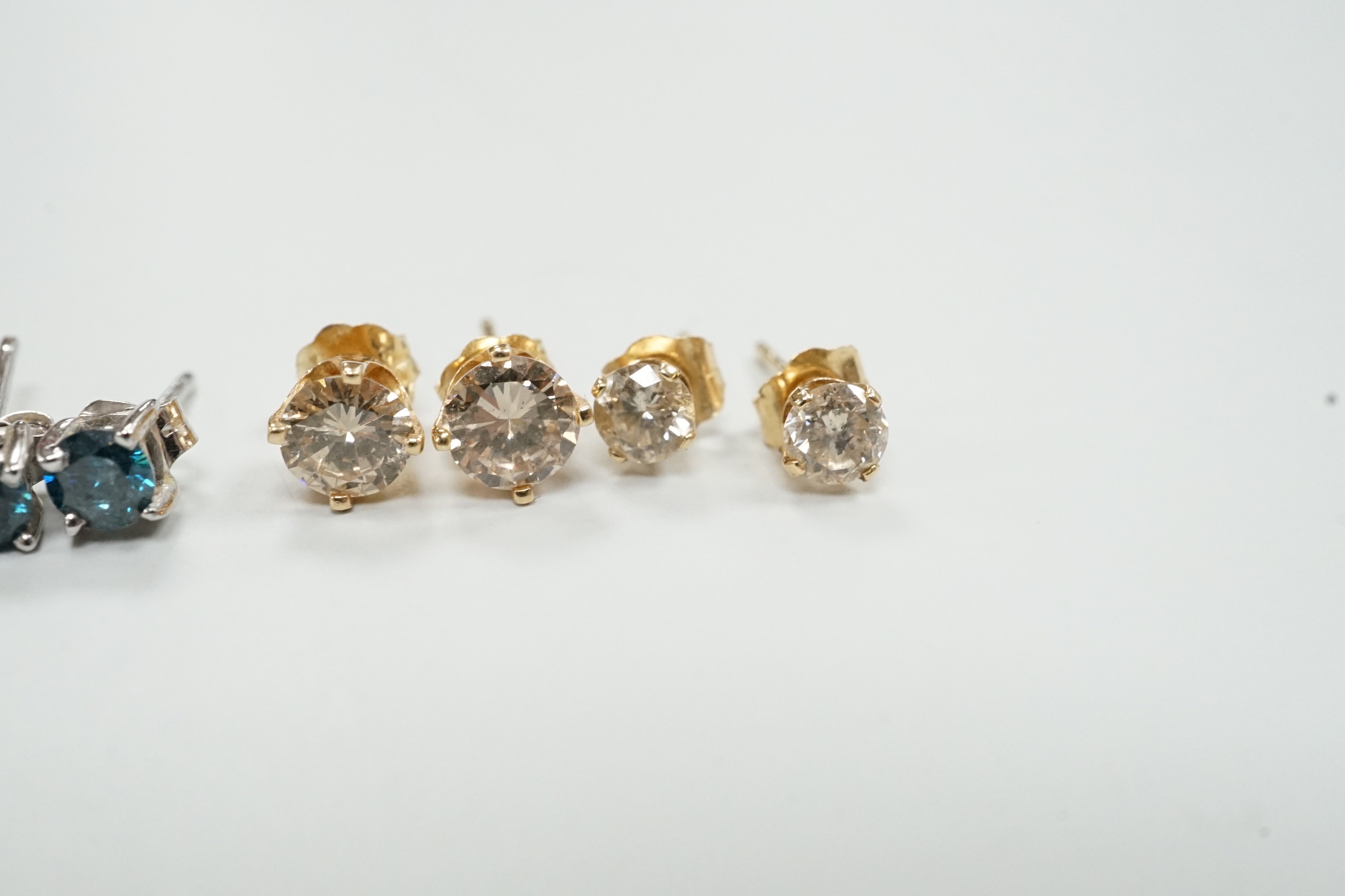 Four assorted pairs of yellow or white metal and diamond set ear studs, including coloured stones.